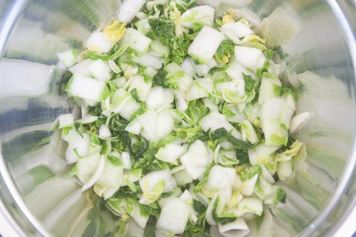 Chopped Napa cabbage in a metal bowl for a Korean Kimchi recipe.