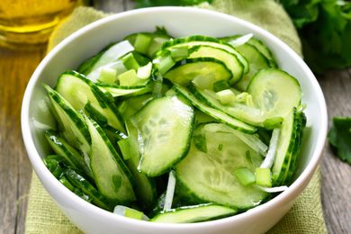 A bowl filled with freshly sliced cucumbers and onions for a salad