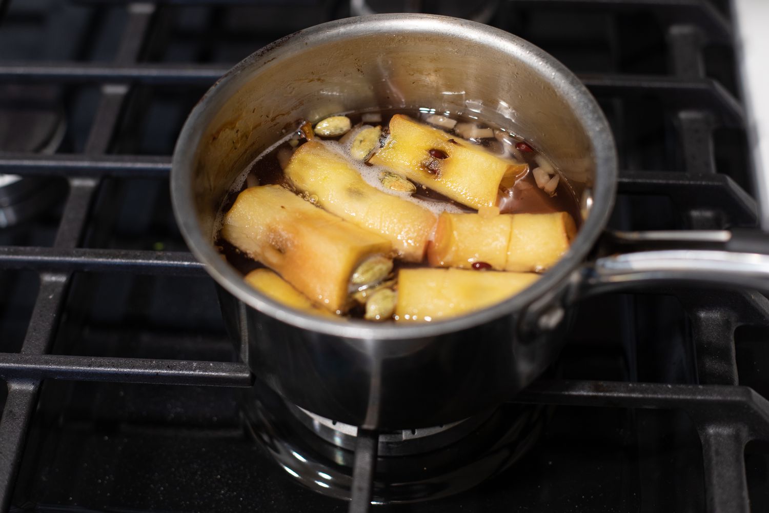 Boiling the apple cores, spices, ginger, and water for simple syrup