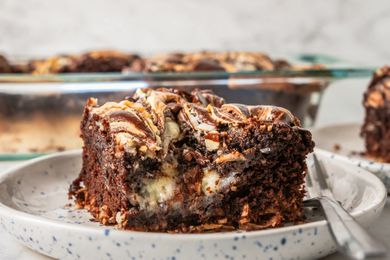 close-up of earthquake cake slice on a small plate and in the background, more cake in the pyrex dish