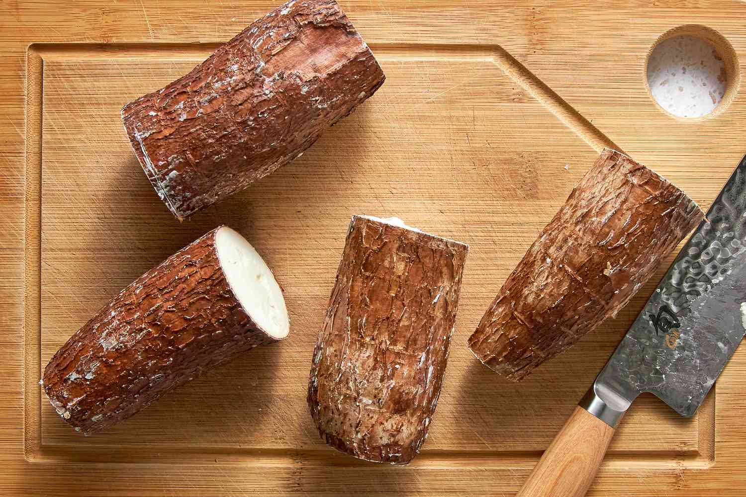 Cassava Root on a Cutting Board With a Knife (Roots Not Peeled)