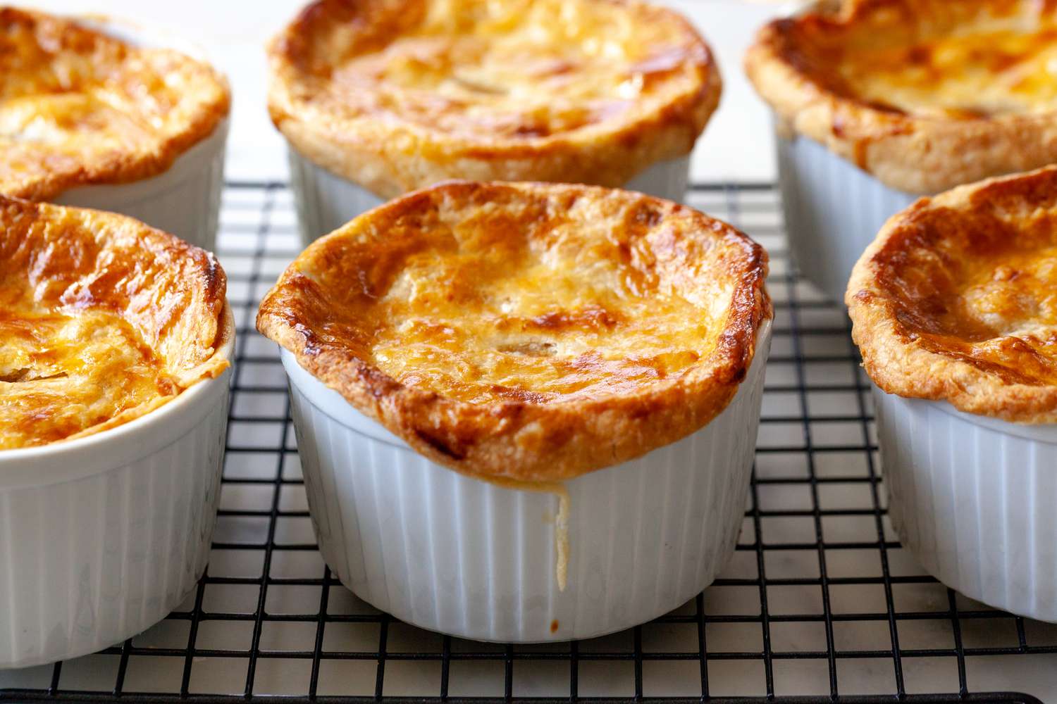 Cajun turkey pies cooling on a wire rack.