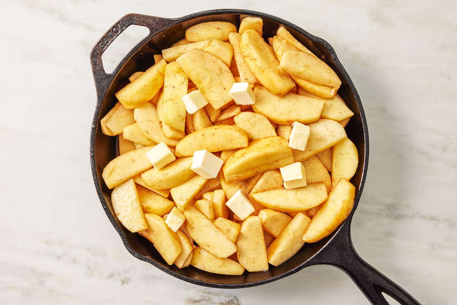 Sliced apples and cubed butter in a skillet for the Apple Pandowdy Recipe