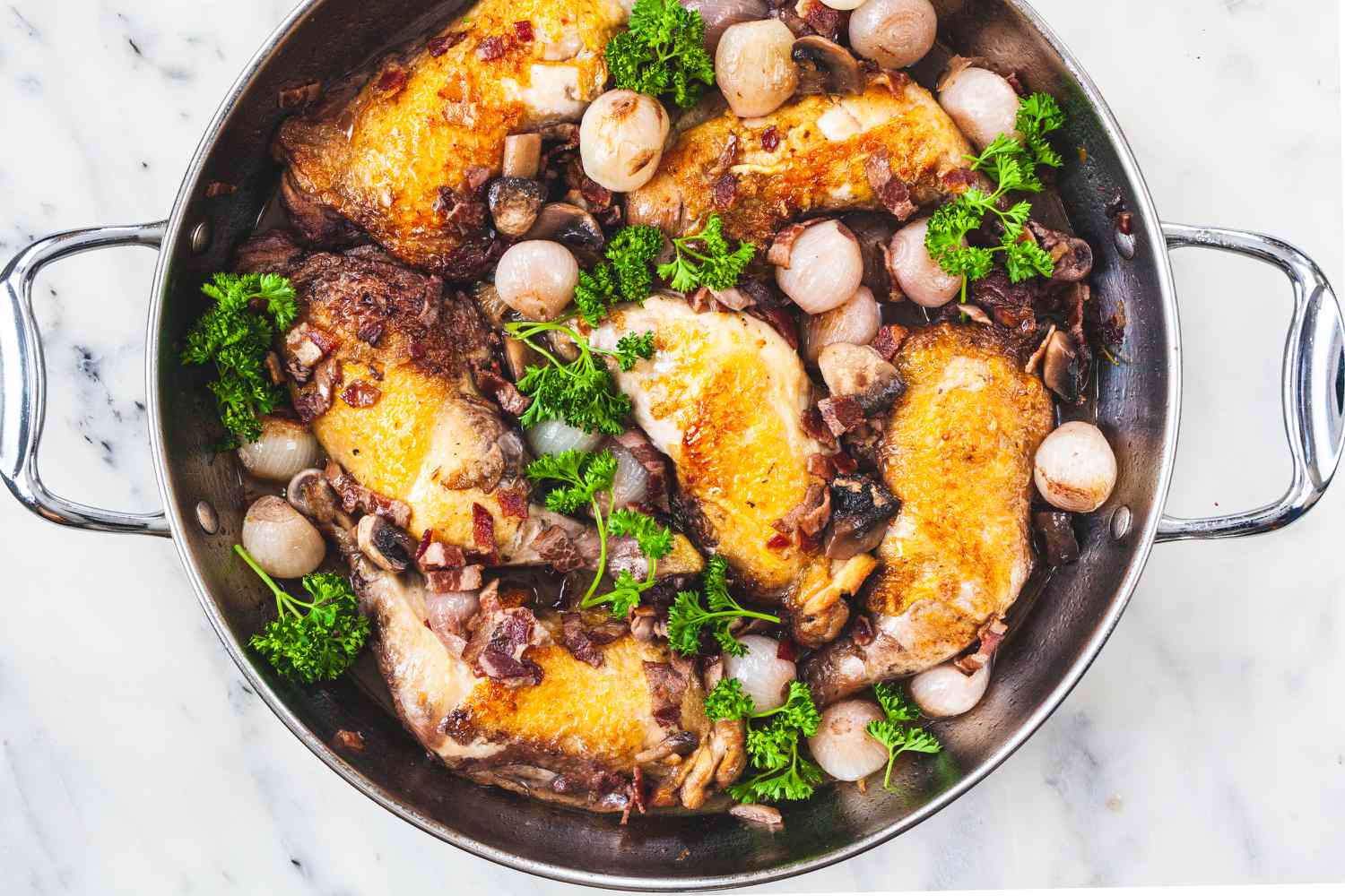 Overhead view of a put with ingredients inside to make coq au vin.