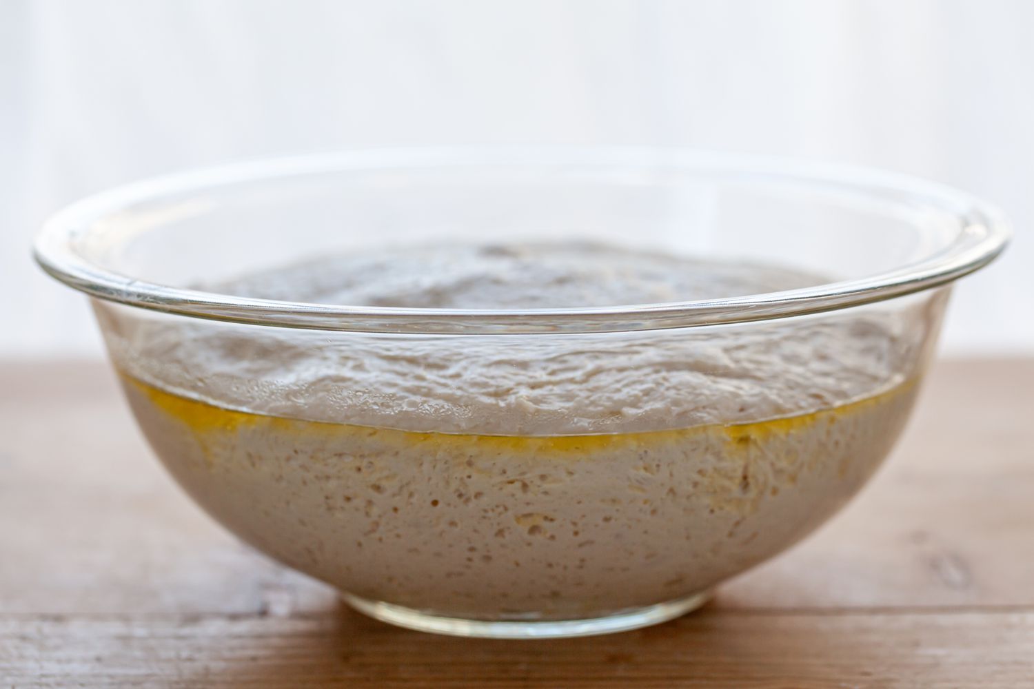 Pizza dough rising in a bowl.