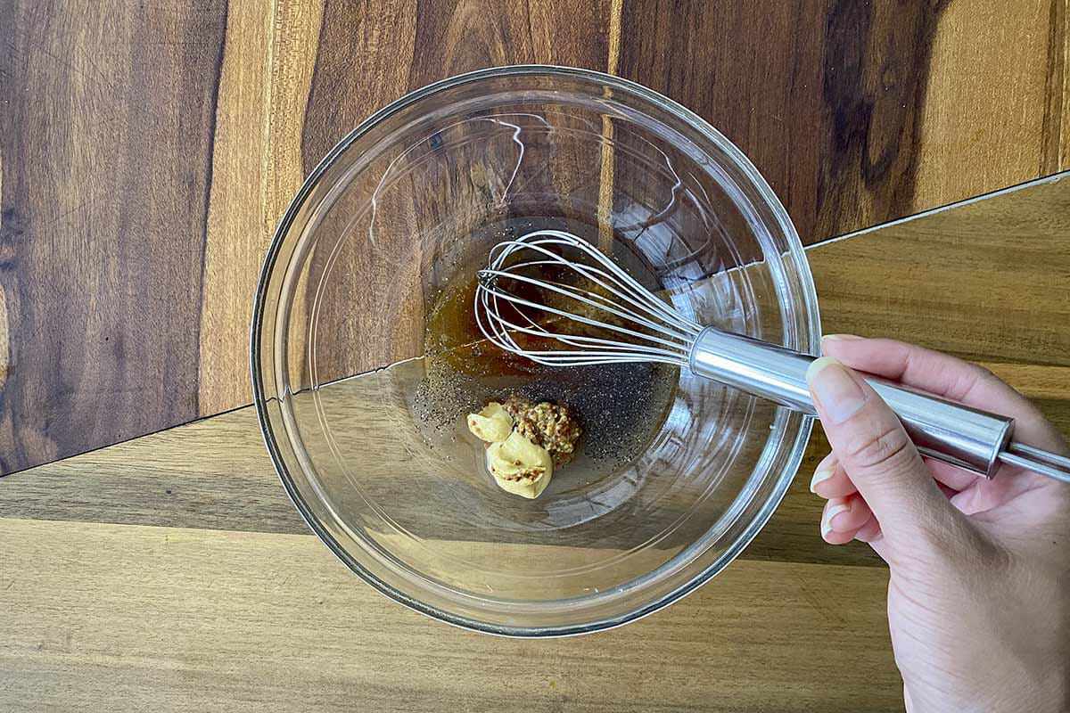 Whisking ingredients for a the vinaigrette for a Raw Kale and Shaved Brussels Sprout Salad with Maple Dijon Vinaigrette.