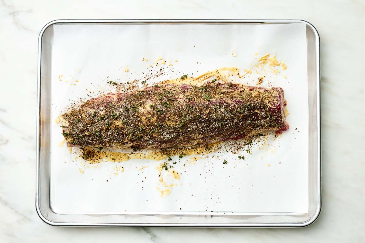 Seasoning Added to Fillet of Meat on a Parchment Paper Lined Baking Sheet for Oven-Roasted Fillet of Beef