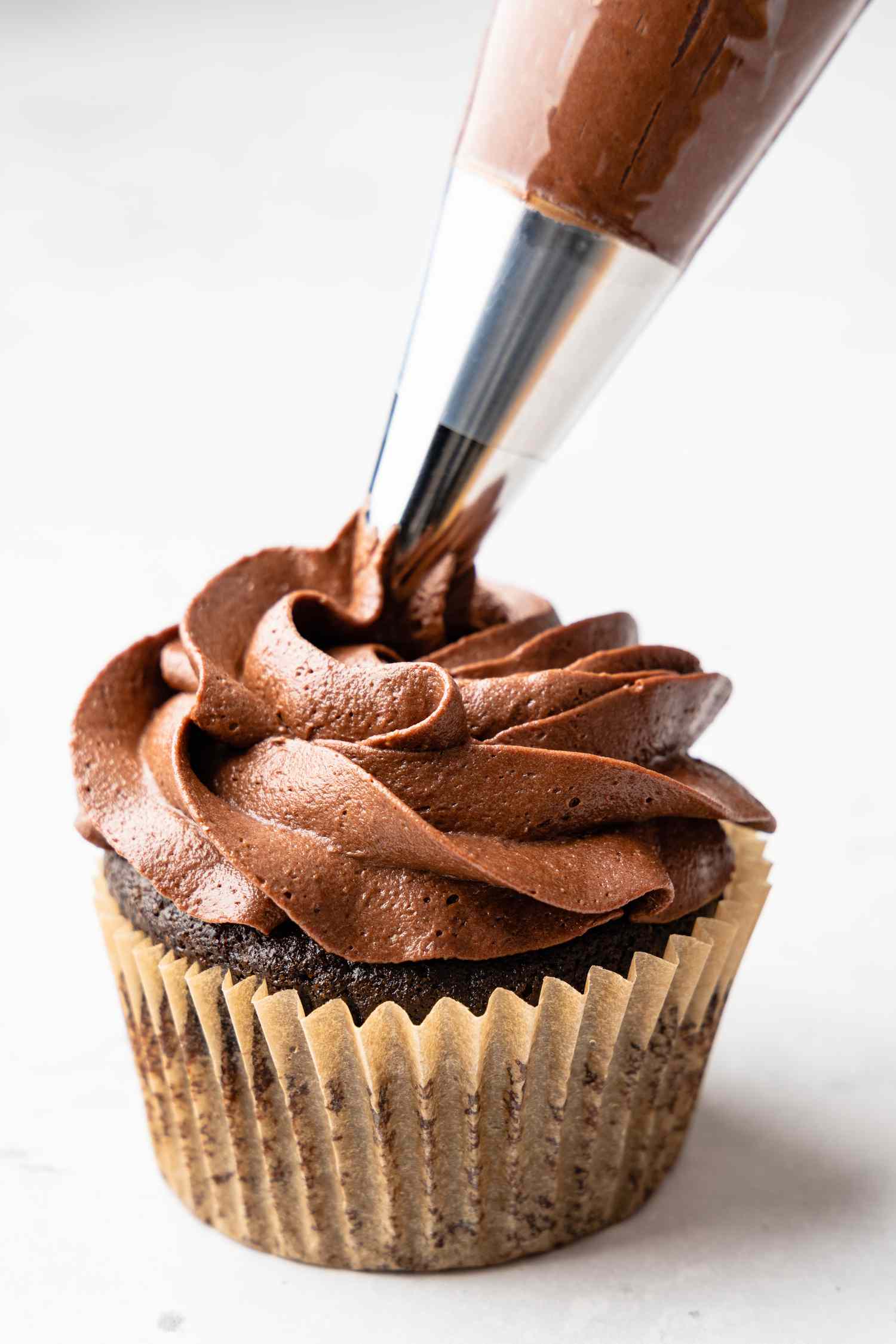 Easy Chocolate Buttercream Frosting Piped onto a Cupcake