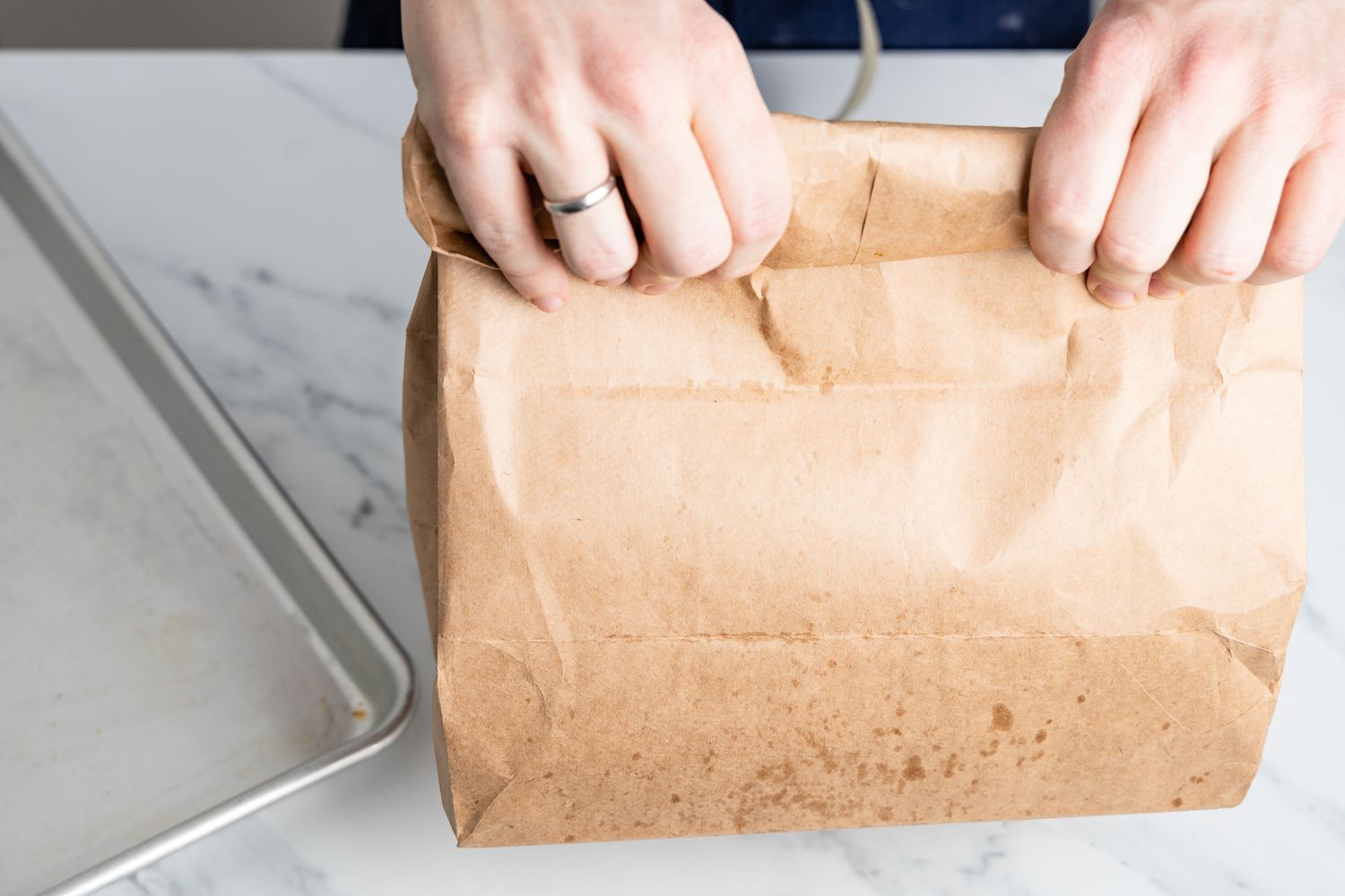folding top of paper bag with hands