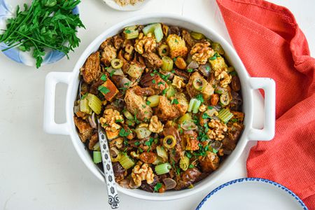 Overhead view of a dutch oven with turkey dressing inside and a red linen next to it.