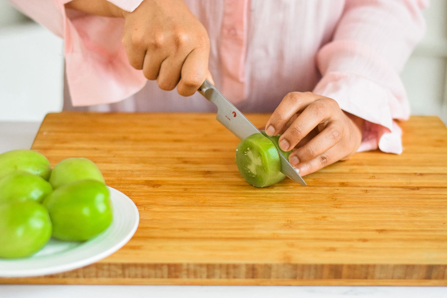 Slicing green tomatoes to show how to make fried green tomatoes