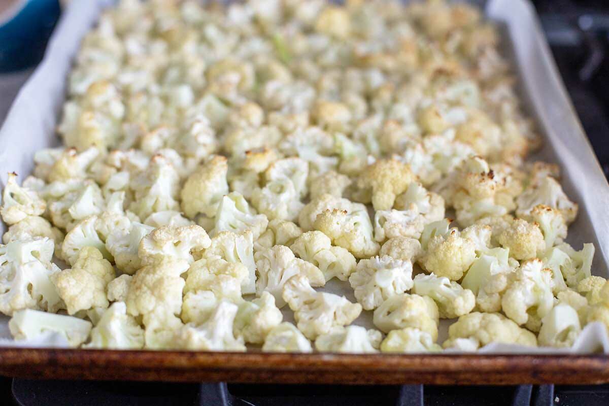 Chopped cauliflower slightly roasted in a baking sheet to make Vegetarian Cauliflower Casserole.