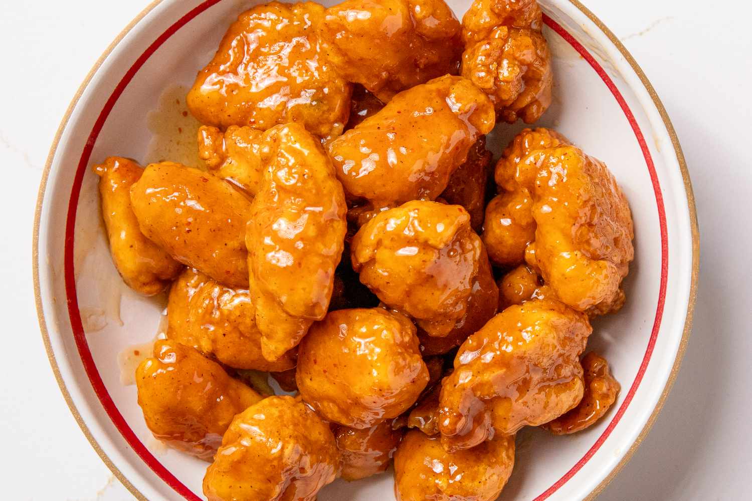 A plate of orange chicken with sauce