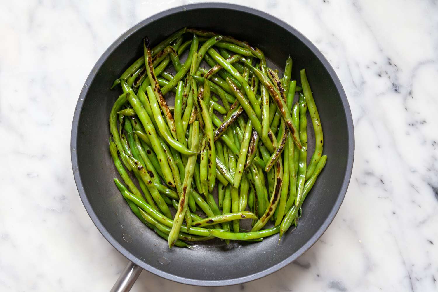 Spicy Korean Blistered Green Beans with Gochujang cooked in a skillet.