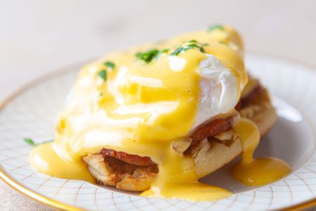 Side view of eggs benedict on a plate.