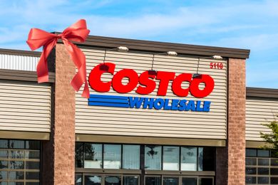 The entrance of a Costco Wholesale store featuring a red bow decoration on the building