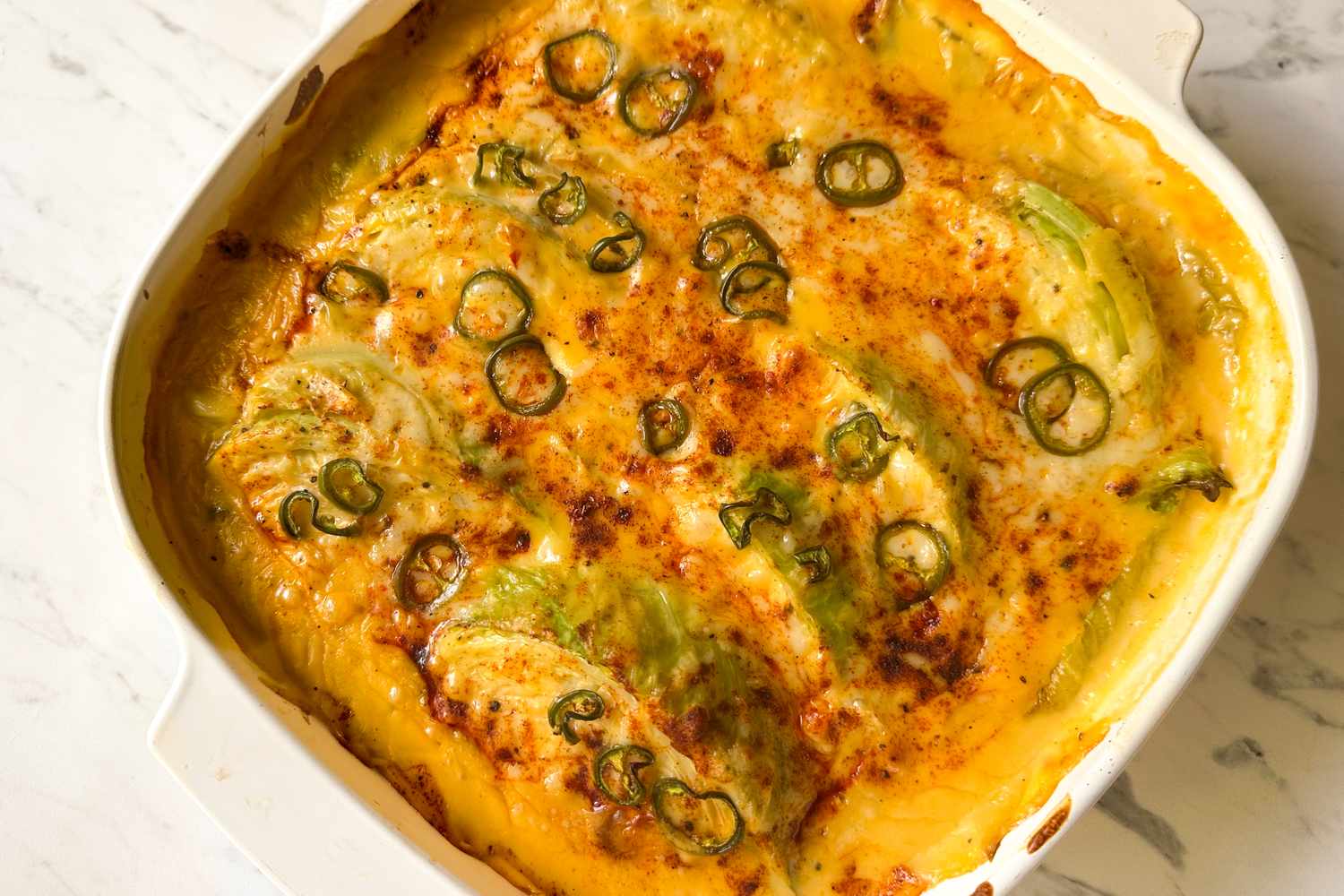 Baked cabbage dish with cheese and jalapeo slices in a casserole dish