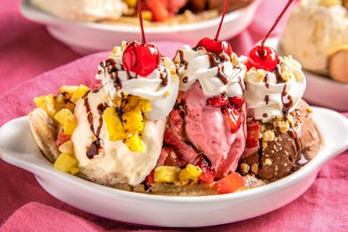 Grilled Banana Split Topped With Chocolate Sauce, Peanuts, Whipped Cream, and Three Maraschino Cherries in a Banana Split Dish