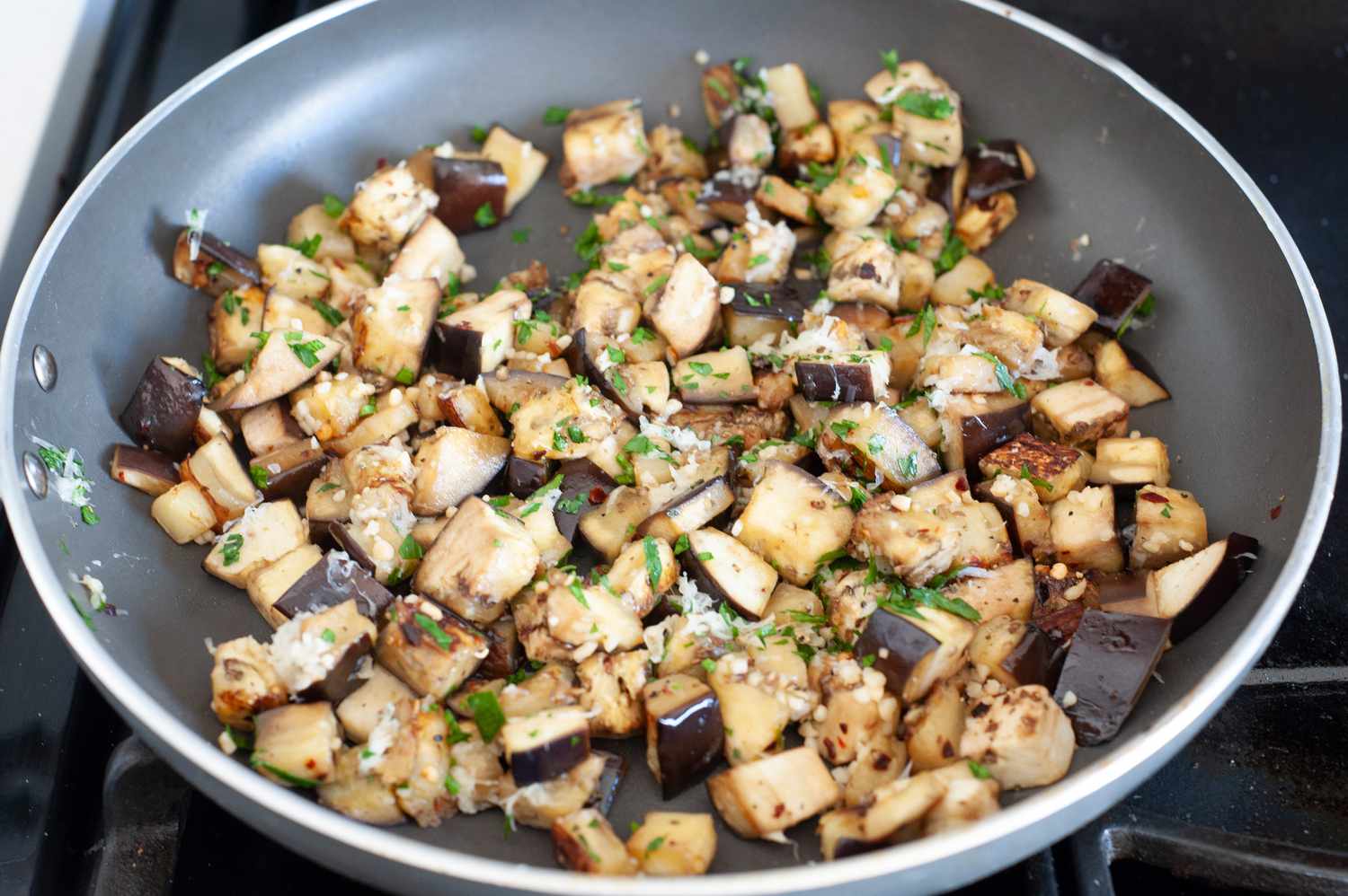 Parmesan and Herbs Added to Sautéed Eggplant with Garlic 