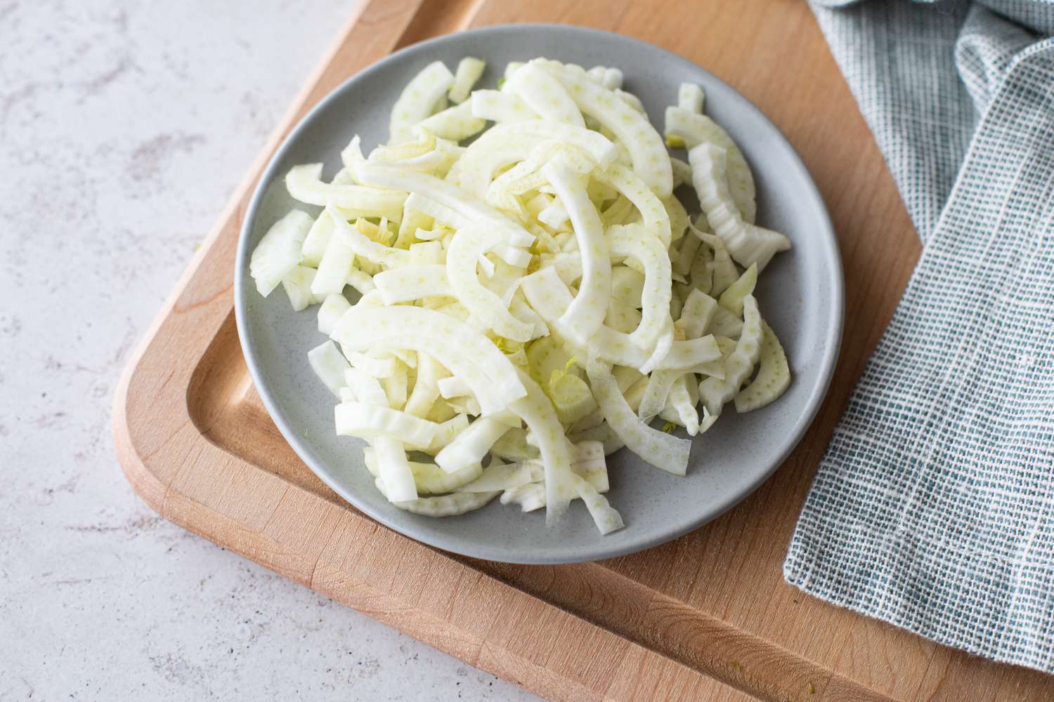 Sliced fennel on a wooden cutting board