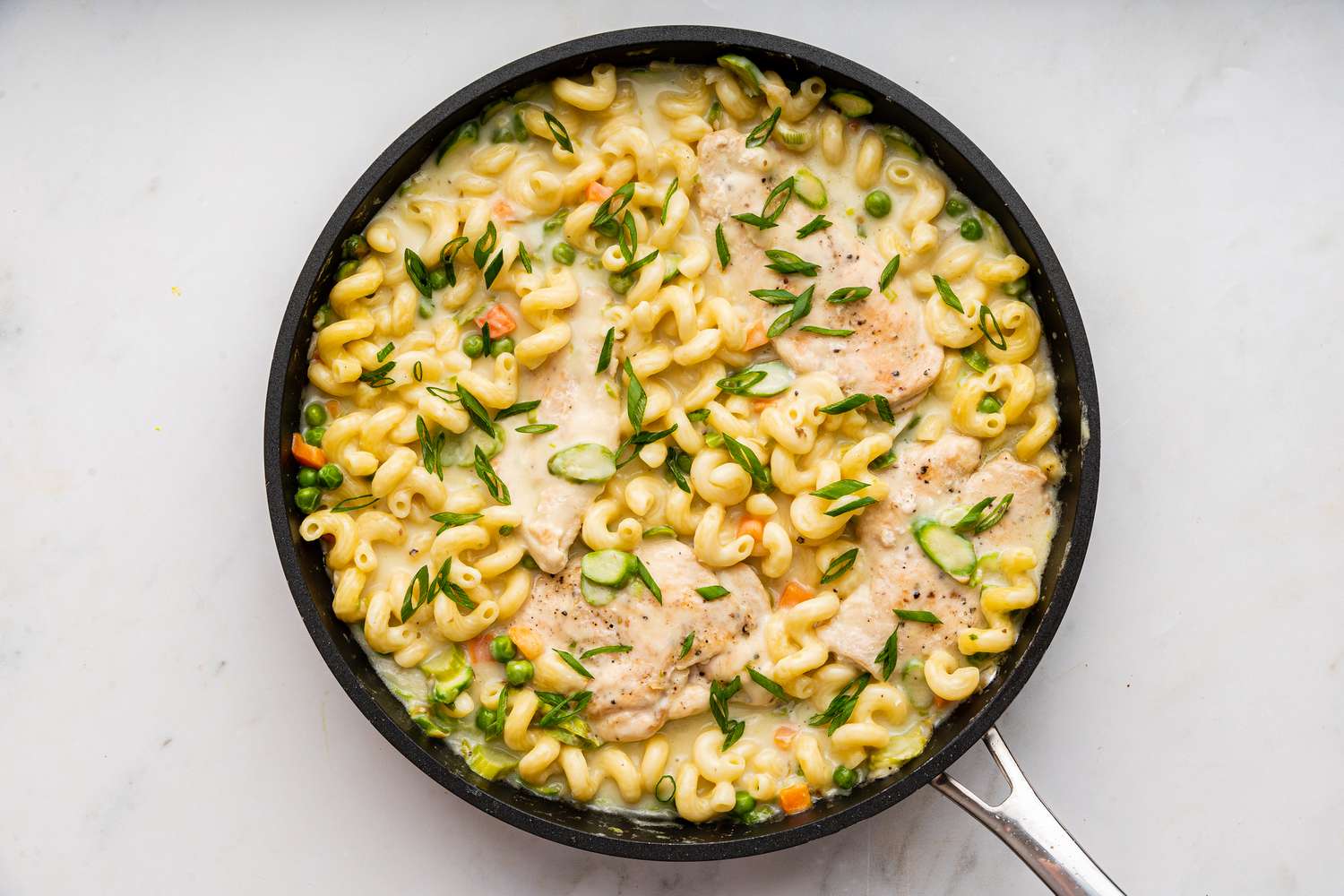 chicken added to pan with cooked pasta for easy chicken primavera recipe