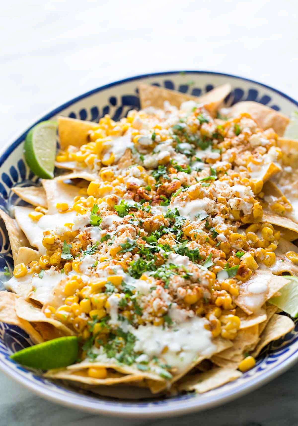 Bowl of Mexican Street Corn Nachos Served With Lime Wedges