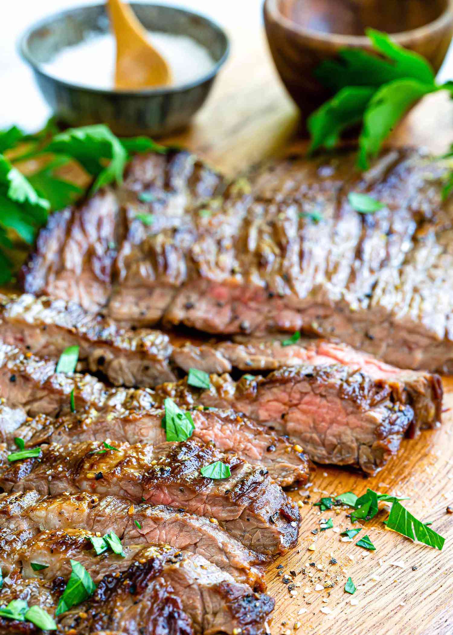 How to Cook Skirt Steak in a Pan - sliced steak with herbs on top