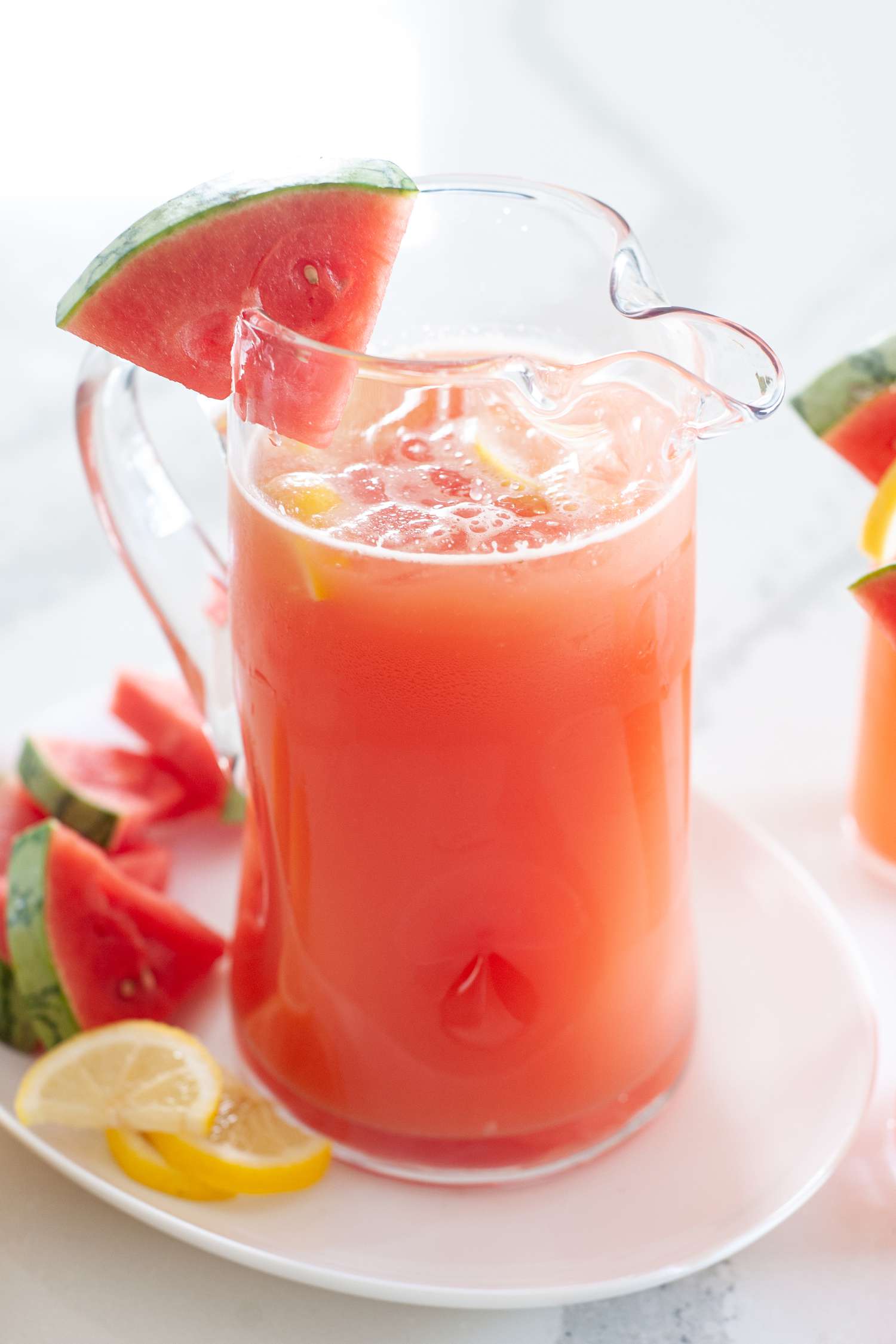 Side view of blender watermelon lemonade served in a pitcher.