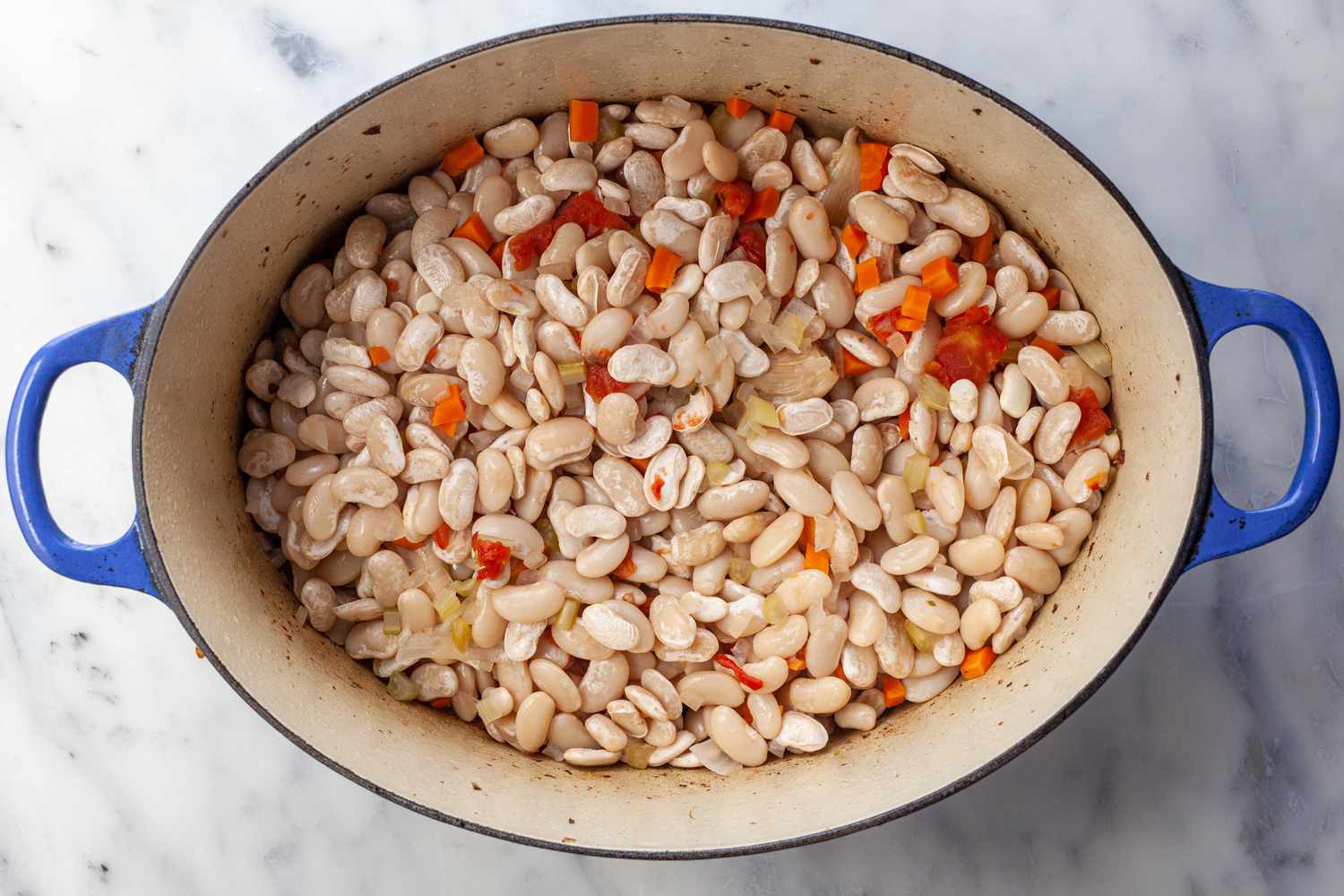 Add first layer of beans to Dutch oven.