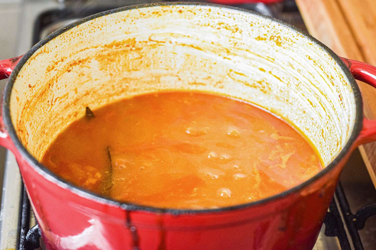 Dutch oven with simmering sauce for pulled pork.