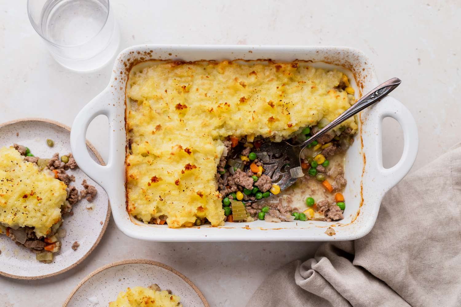 A casserole dish with a piece of shepherd's pie removed.