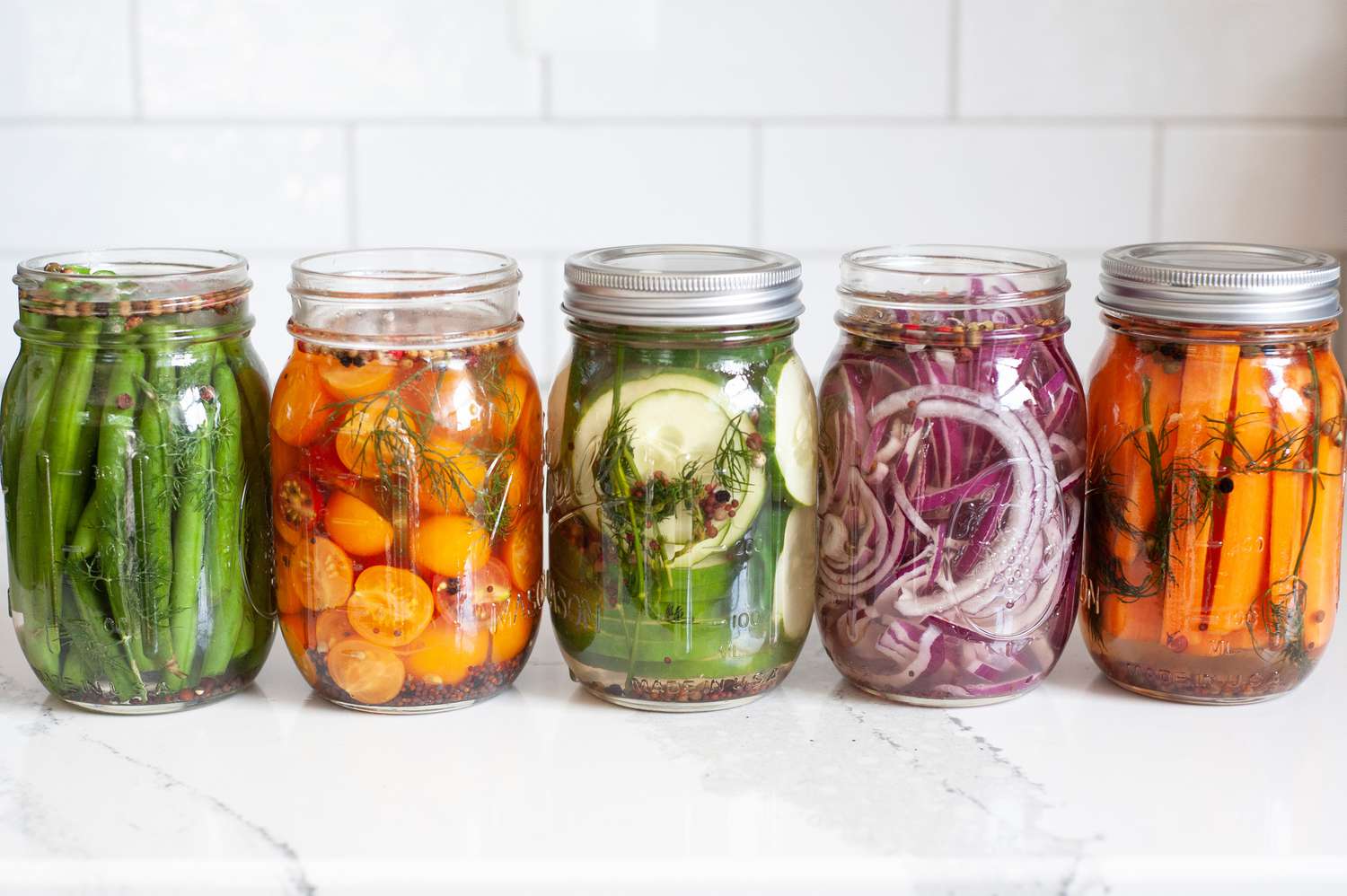 Jars of Quick Pickles (One with Cucumbers, Another with Carrots, Another with Red Onions, Another with Cherry Tomatoes, and the Last with Green Beans)