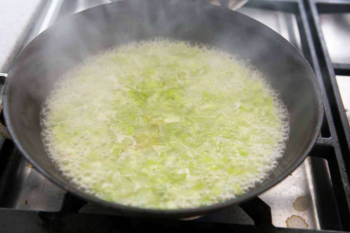 Braised celery beginning to cook down and simmer in the pot
