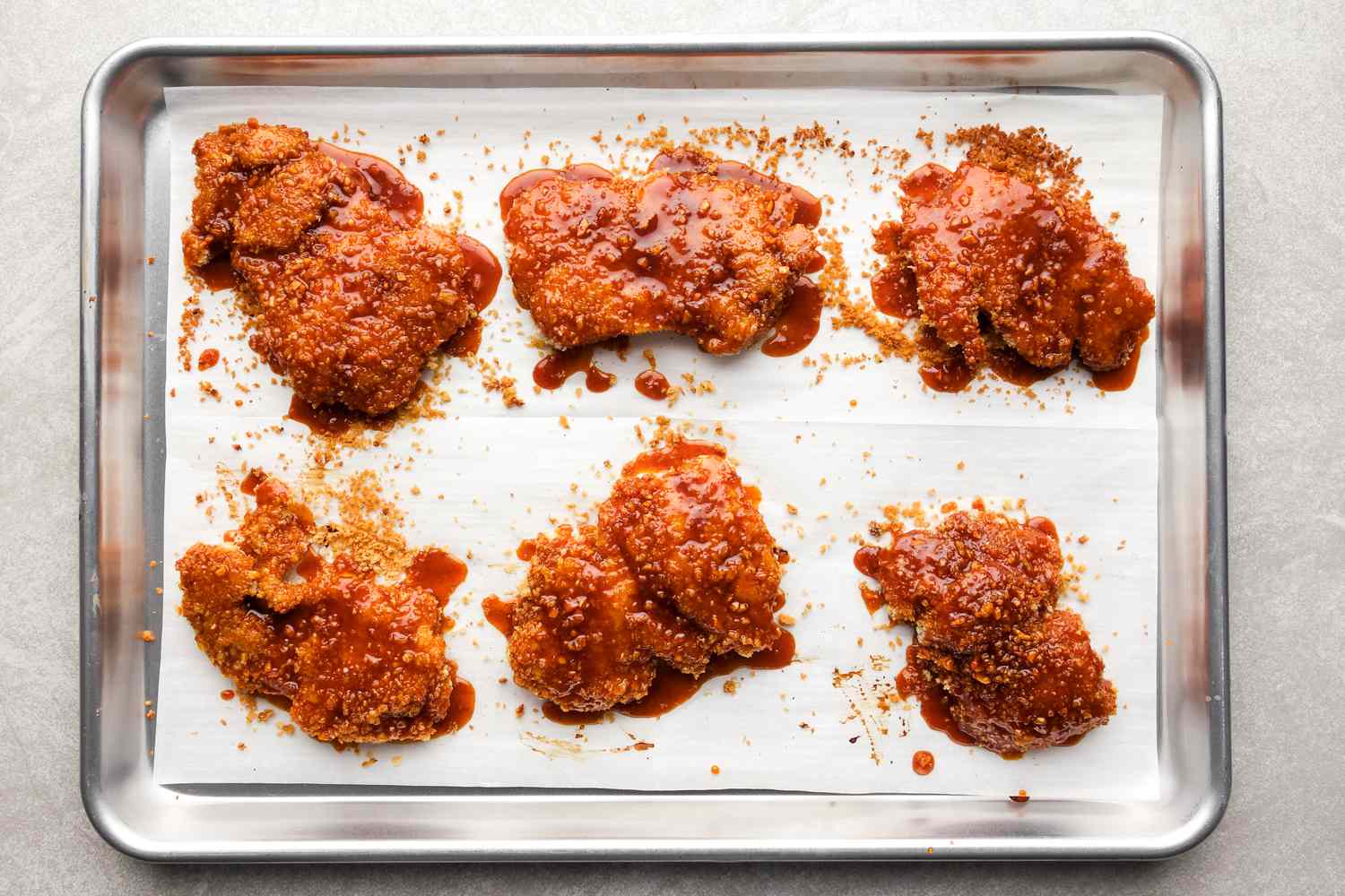 Oven-fried hot honey chicken on sheet pan.