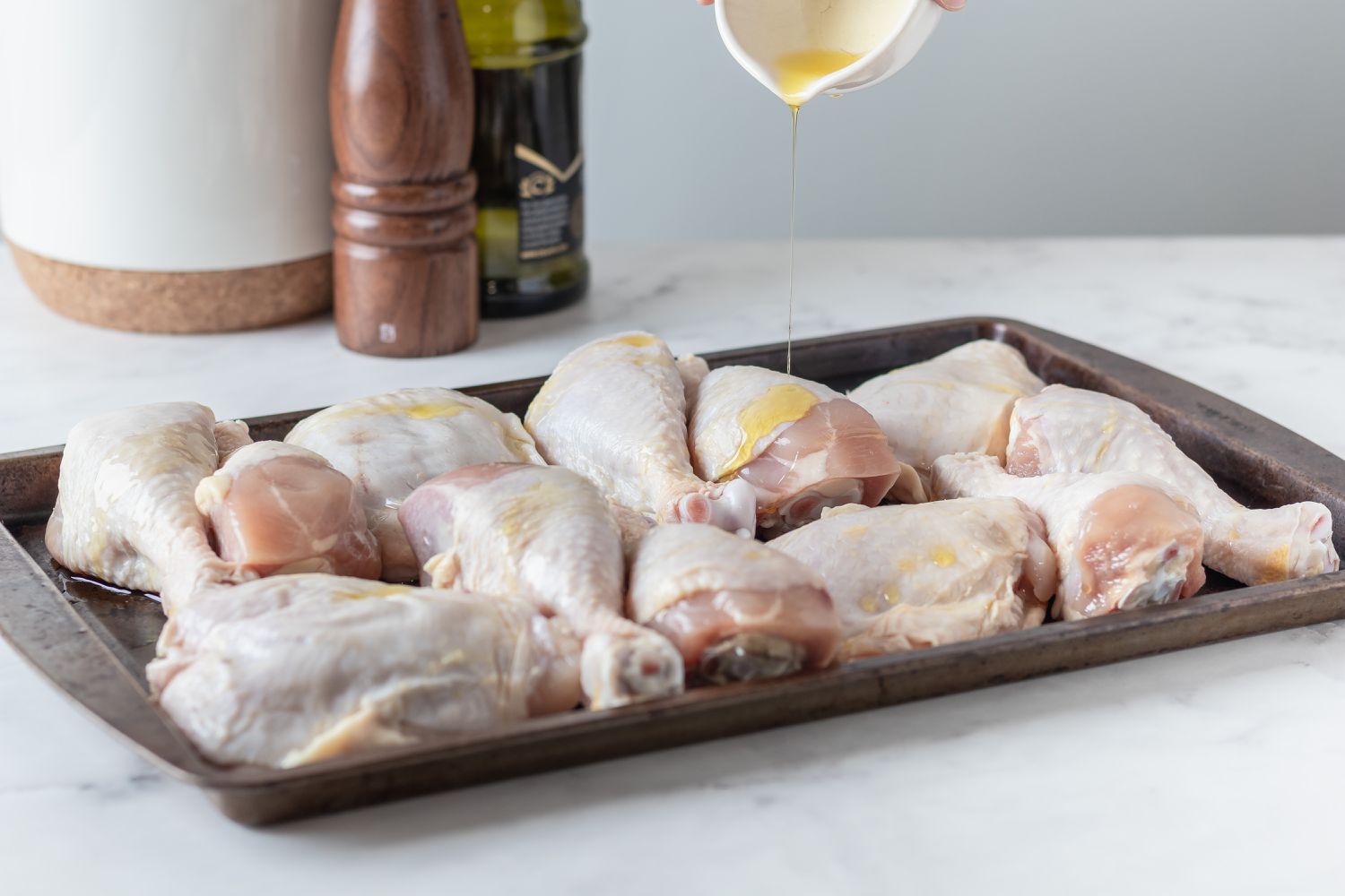 Side view of chicken on a baking sheet to make a bbq chicken recipe.