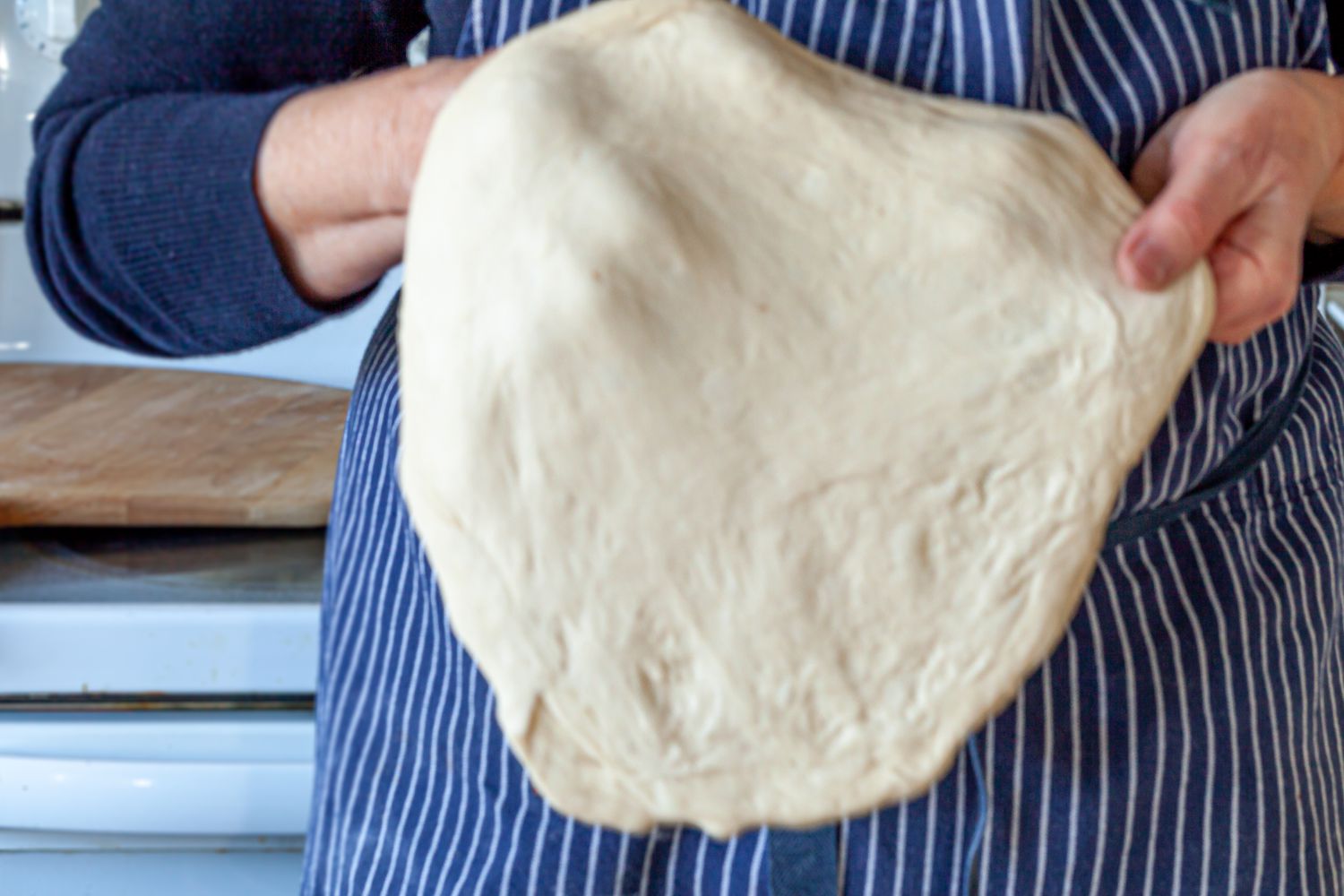 Stretching homemade pizza dough.
