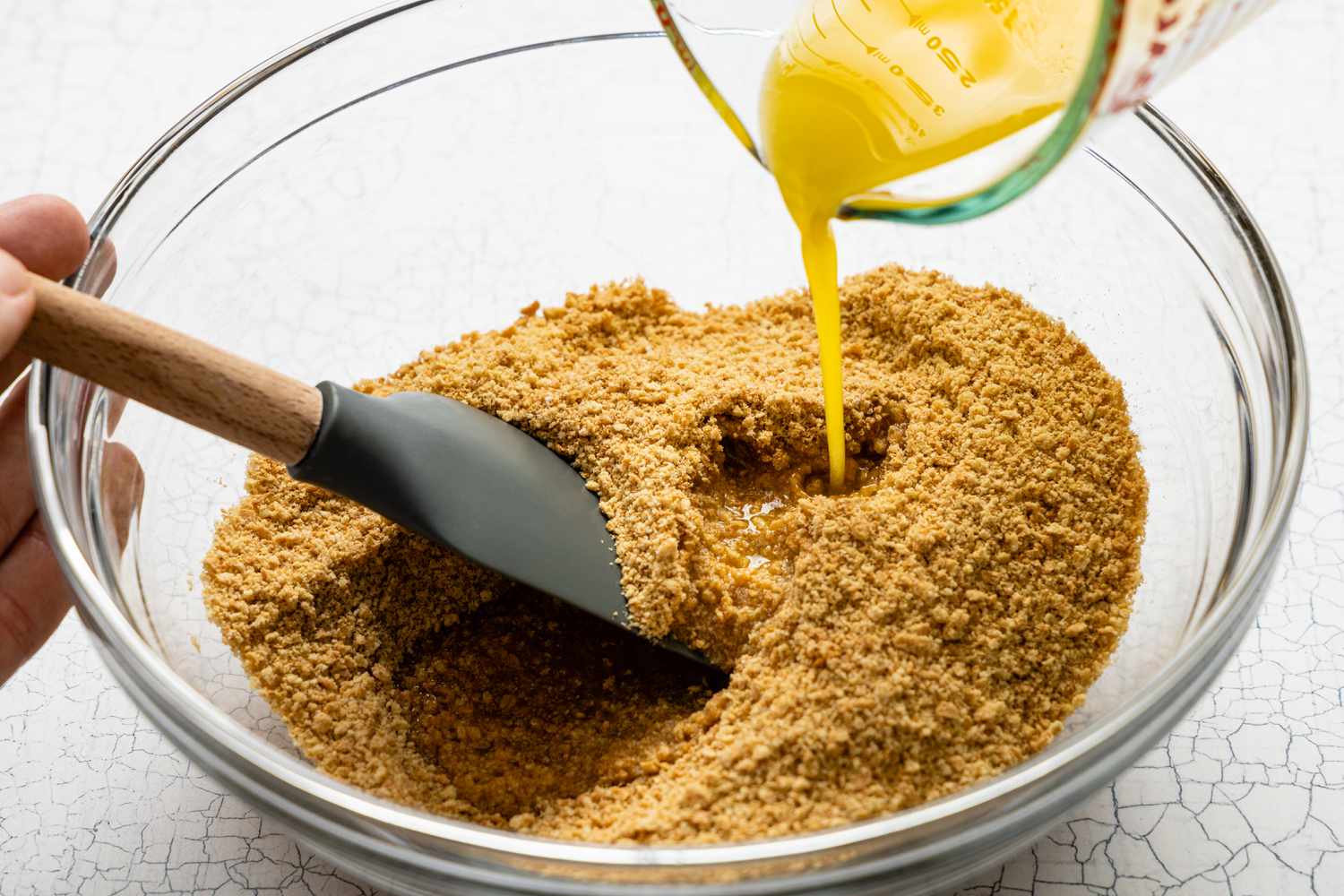 Melted Butter Poured into a Bowl with Graham Cracker Crumbs for British Banoffee Pie 