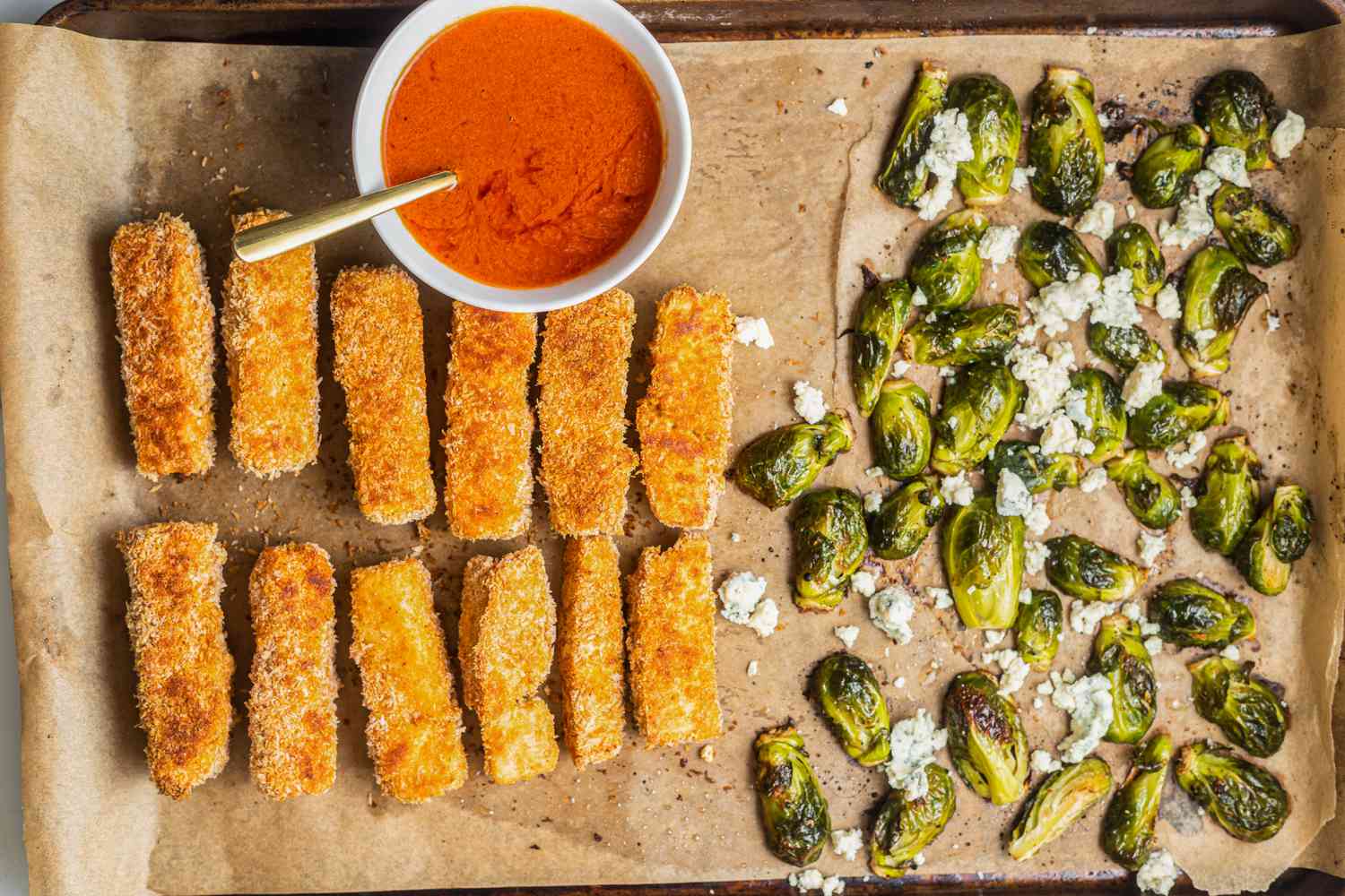 Sheet Pan Buffalo Tofu, Blue Cheese Brussels Sprouts, and Bowl of Buffalo Sauce on a Baking Sheet 