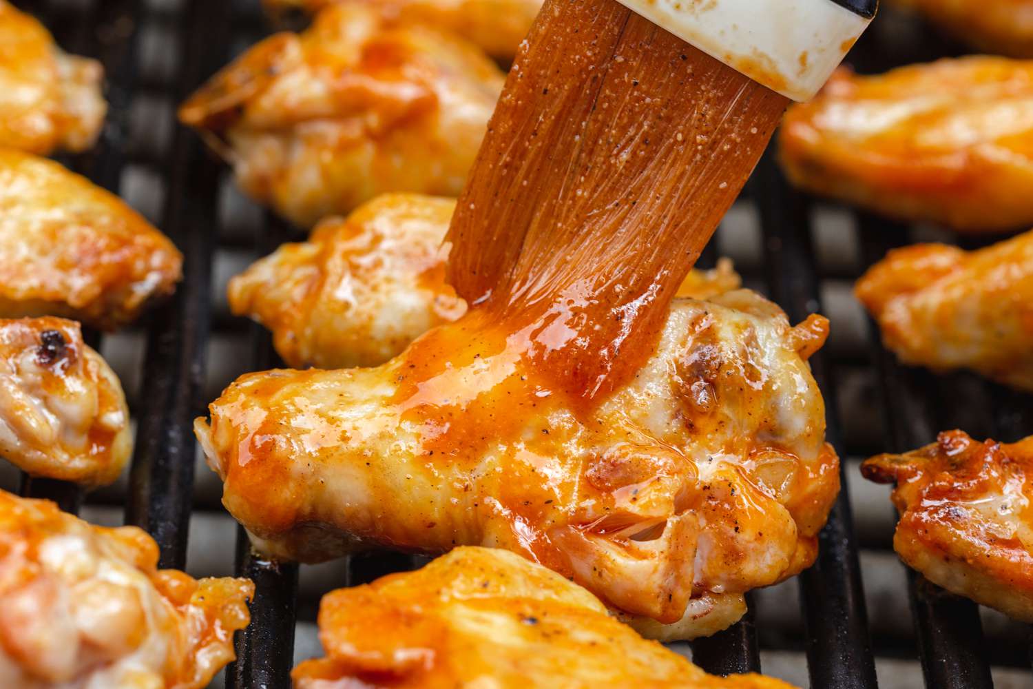 Basting bbq sauce on grilled wings.