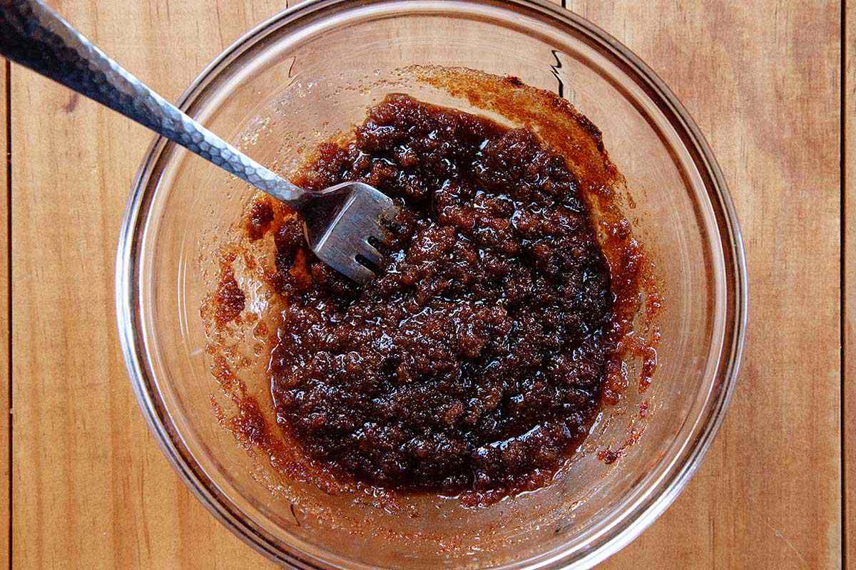 A fork is in a glass bowl with mixed king cake filling.