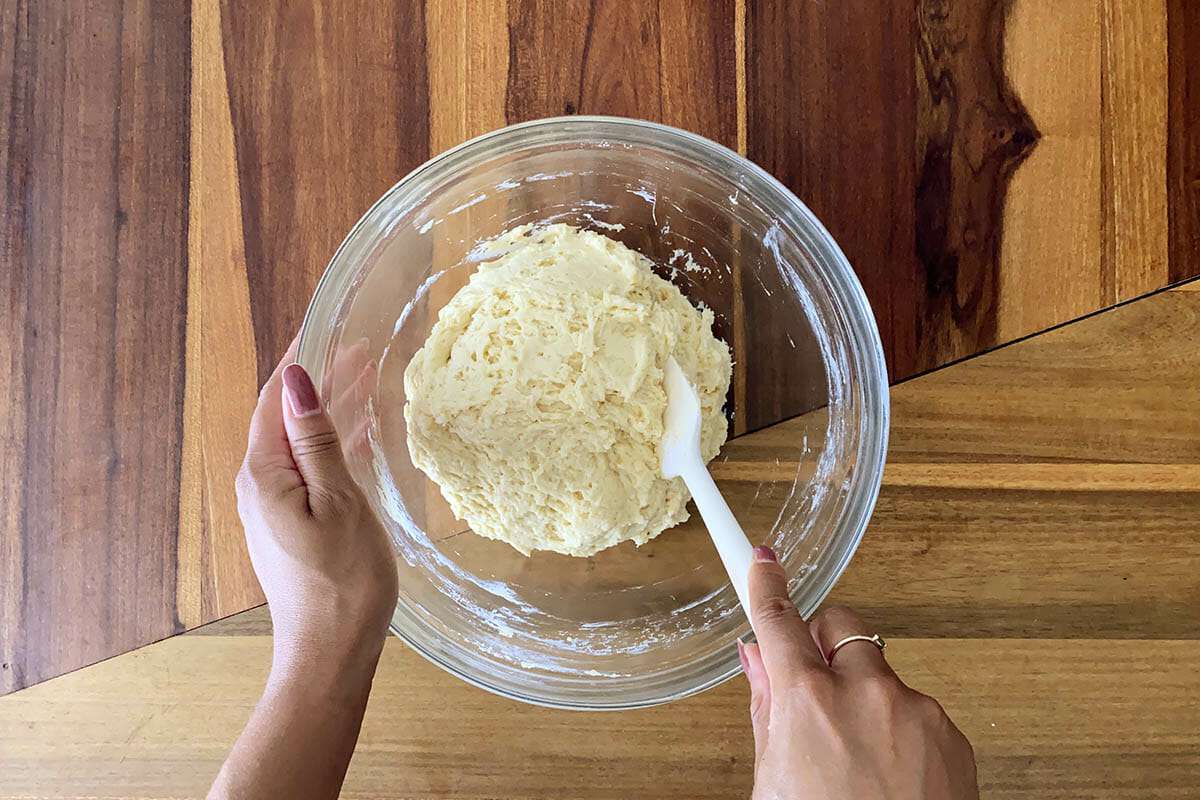 Dough mixed in a glass bowl to show how to make gluten free cinnamon rolls.