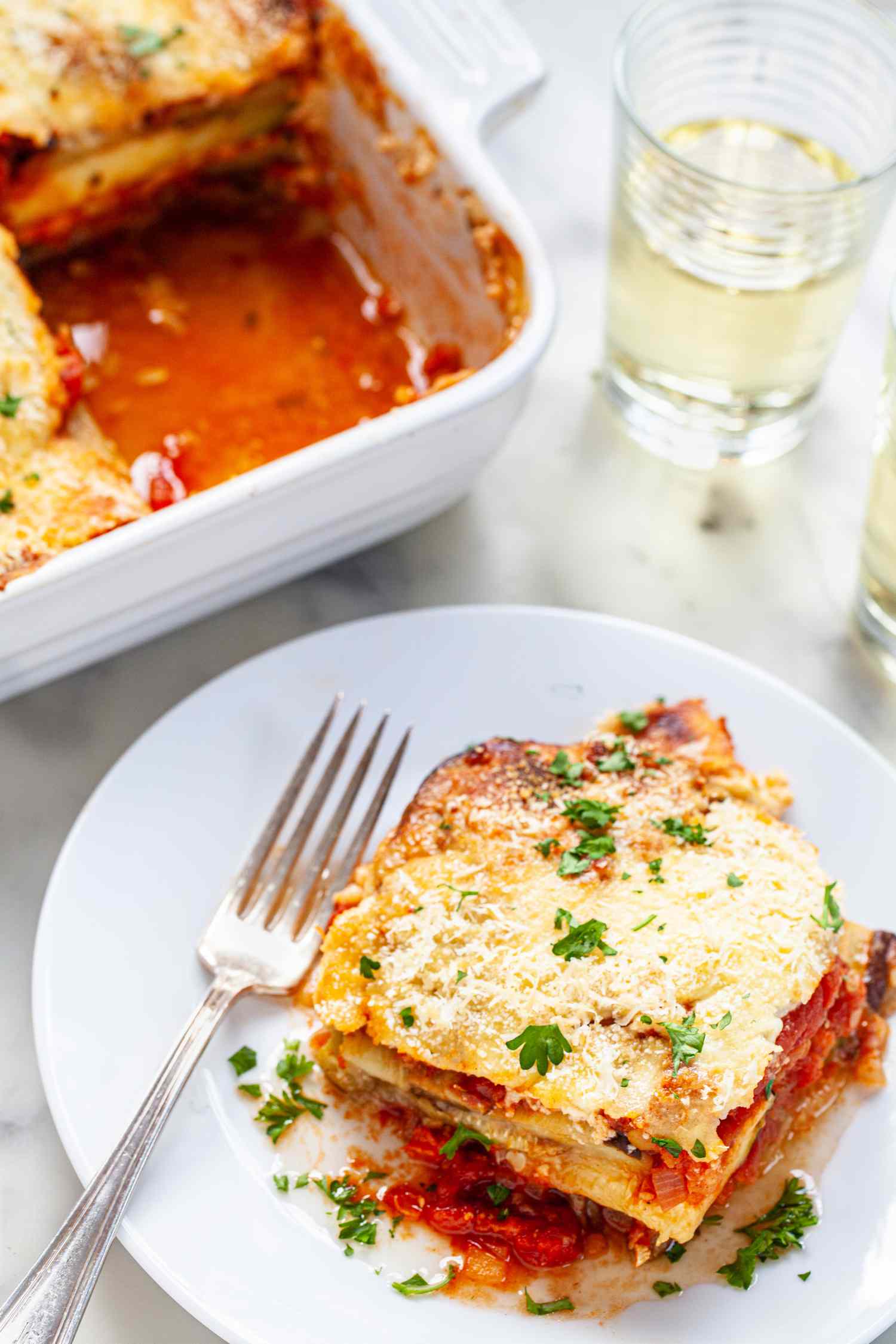 Vegetable moussaka sliced on white plate