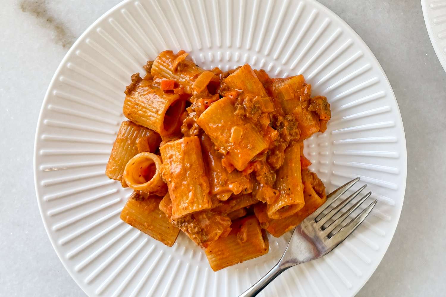 A plate of pasta with Bolognese sauce and a fork