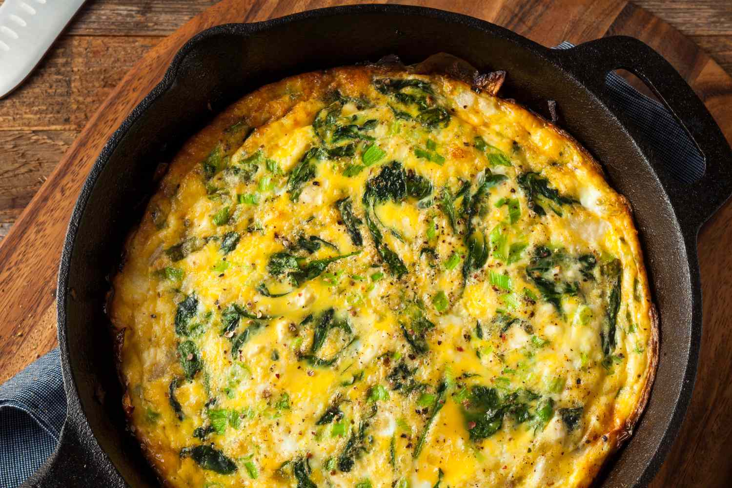Overhead view of an spinach and feta omelette in a cast iron skillet