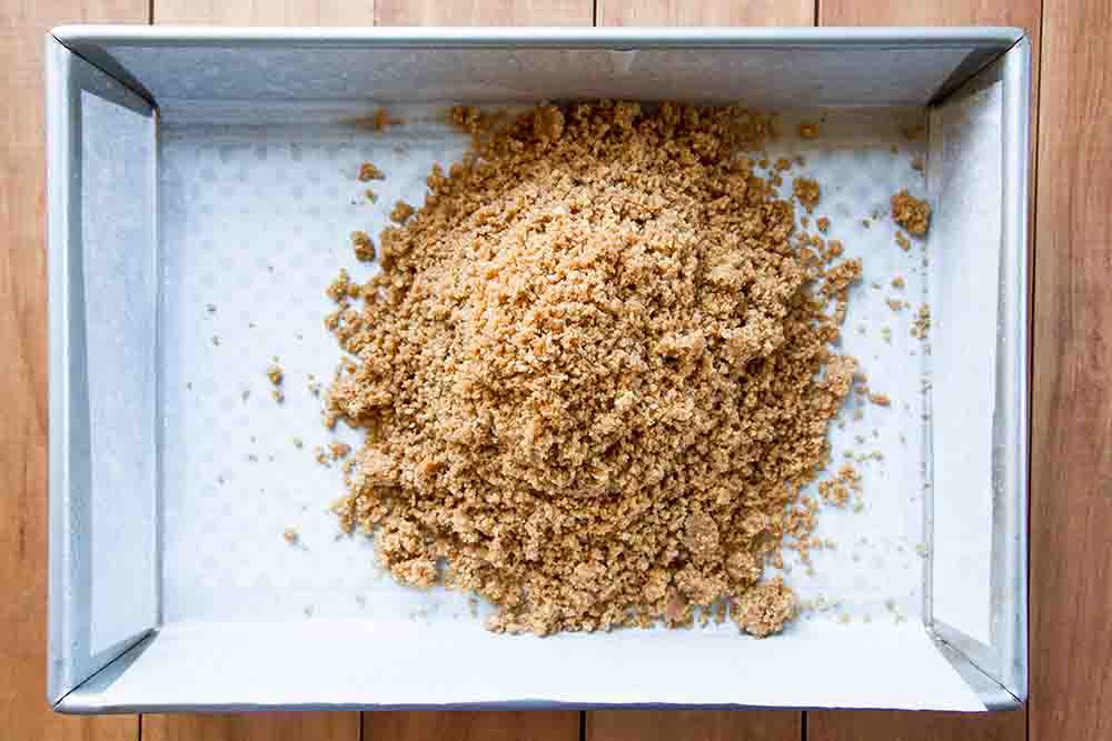 The graham cracker layer for Magic Cookie Bars in a baking dish