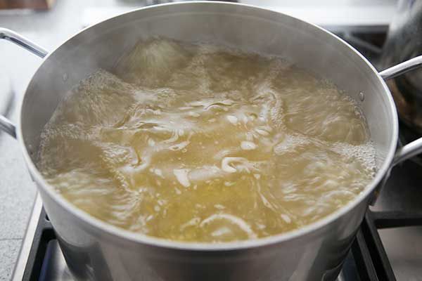 A boiling chicken stock in a stock pot