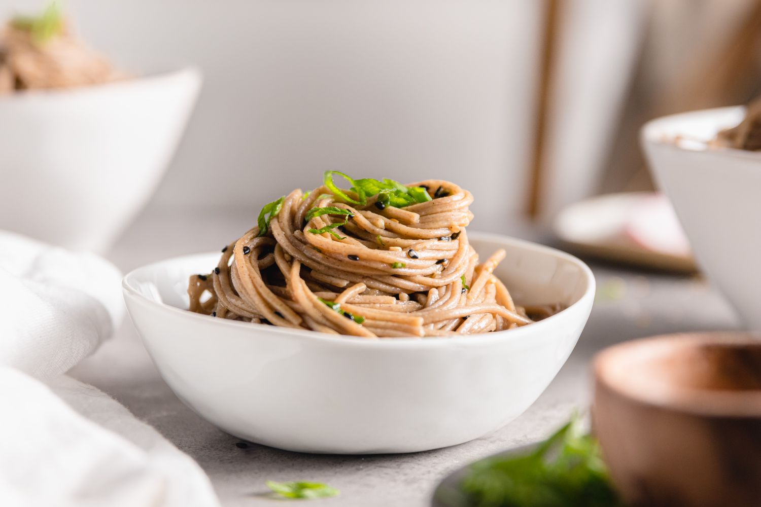 Sesame Soba Noodles in a Bowl Surrounded by More Bowls of Noodles