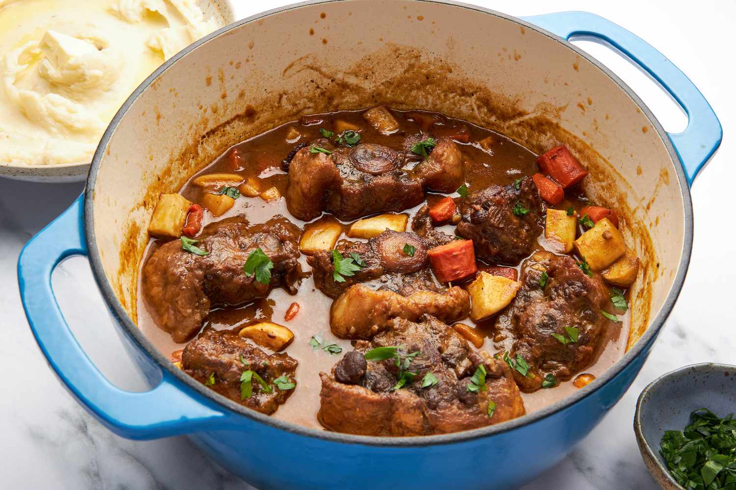A Dutch oven full of oxtail stew on a counter