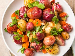 A plate of roasted root vegetables with garnish including potatoes and carrots