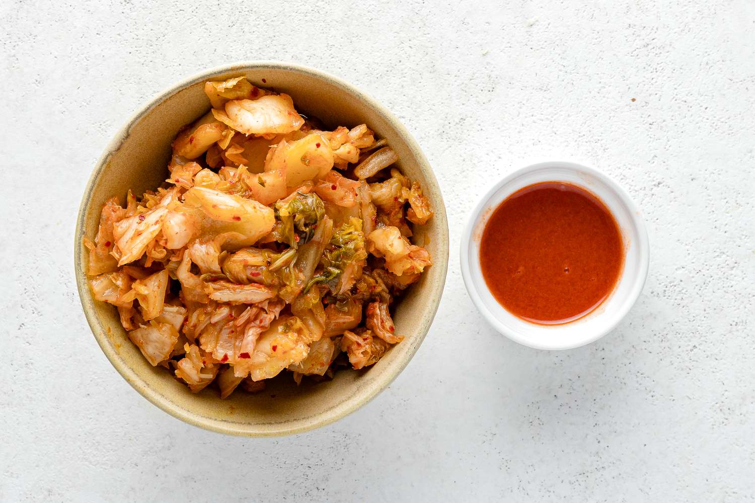 Bowl of Kimchi and a Smaller Bowl with Kimchi Juice for Fried Rice in a Sheet Pan